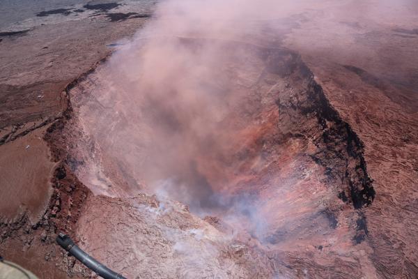 a large crater with smoke coming out of it