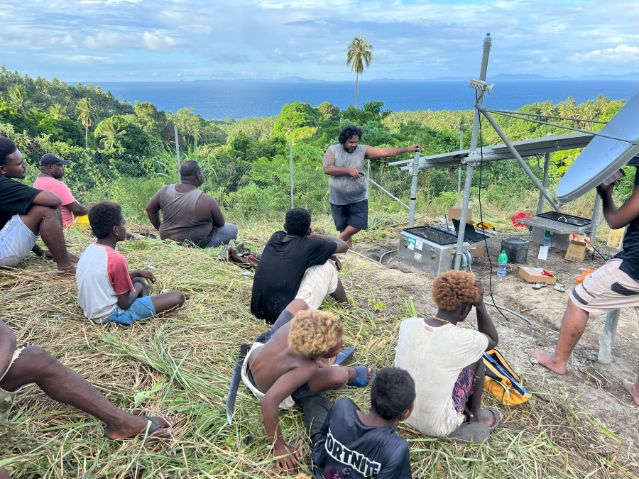 Volcano scientists show a newly installed, VDAP-donated volcano monitoring station to the local community on Savo Island. USGS photo by Brian Mannisto-Meyers.  (Click image to view full size.)